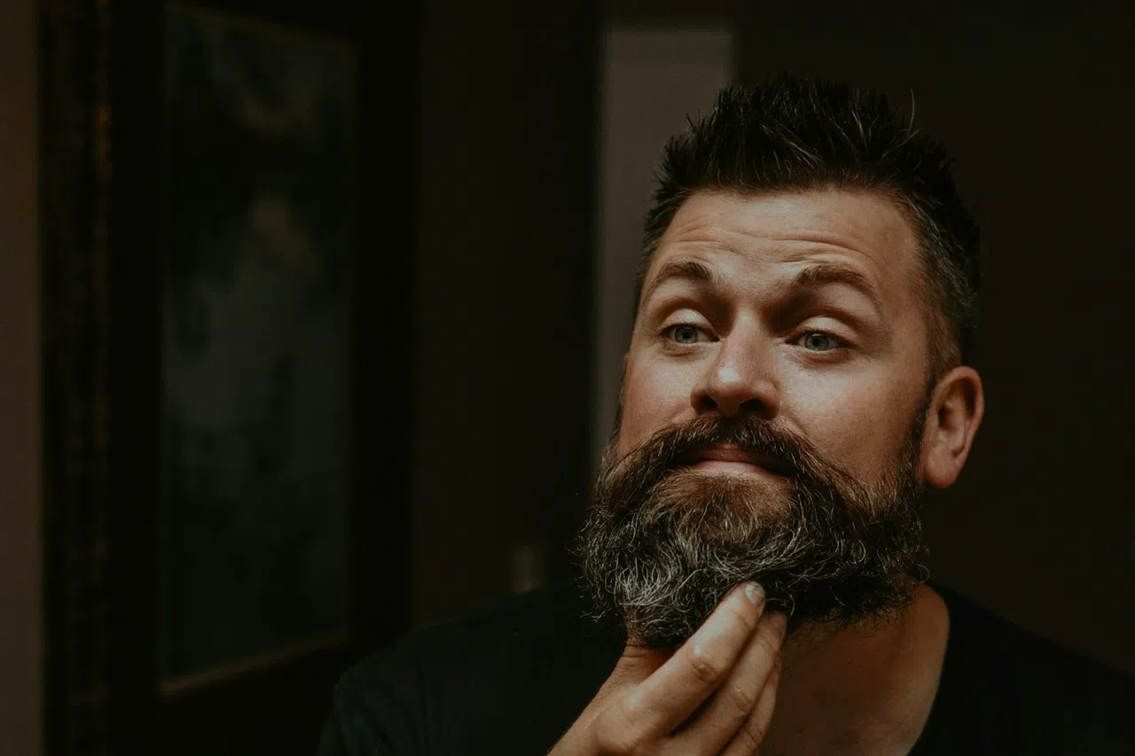 Un barbier fait pénétrer de l'huile dans la barbe d'un client.
